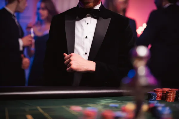 Uma jovem relaxando com o celular enquanto elementos dinâmicos de cassino flutuam ao seu redor, ilustrando a experiência móvel fluida oferecida pelo app 615BET.