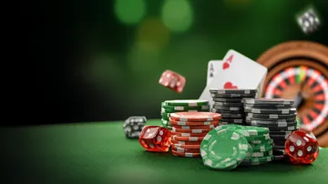 Um close de moedas douradas caindo ao redor de uma roleta girando, representando a ação imersiva do cassino no 615BET.